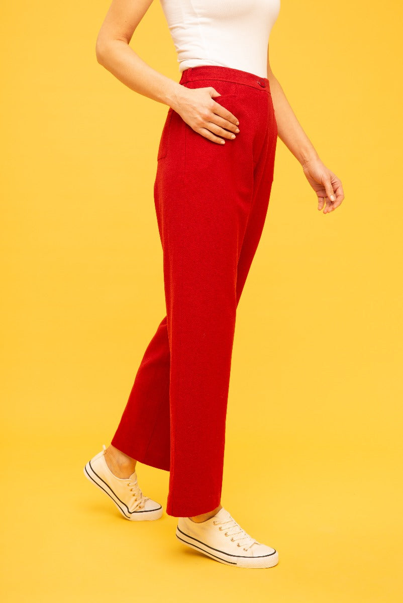 Lily Ella Collection red tailored trousers for women, stylish red pants with pockets, comfortable casual chic clothing, paired with white sneakers on yellow background – Shop Lily Ella's fashion line.