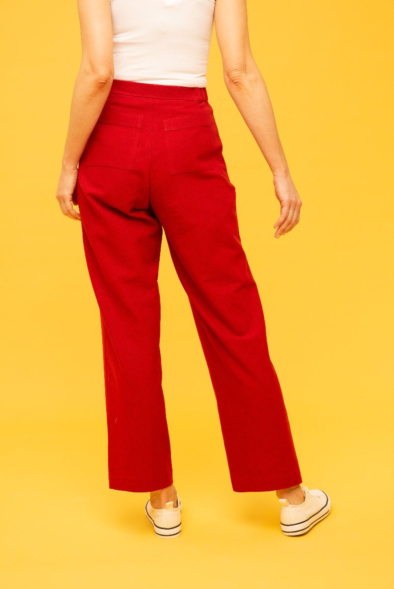 Lily Ella Collection red wide-leg trousers for women on a yellow background, featuring high-waist design, back pockets detail, and casual fit with white sneakers.
