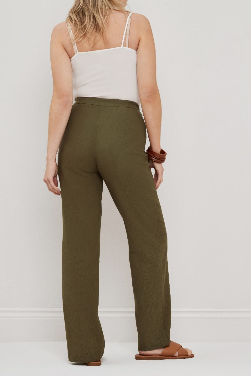 Lily Ella Collection olive green trousers, high-waisted style, wide-leg cut, paired with white strappy top and brown sandals, elegant women's fashion.