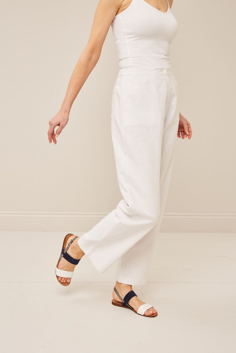Lily Ella Collection elegant white linen trousers with a female model showcasing simplistic style and comfortable fit, paired with casual two-tone sandals