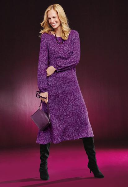 Lily Ella Collection purple paisley print midi dress with long sleeves, elegant black knee-high boots, and matching purple handbag, featured on a model against a magenta background.