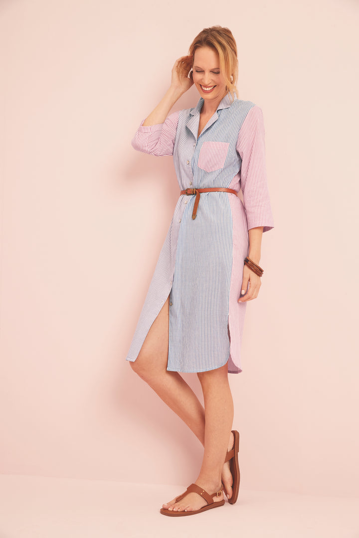 Lily Ella Collection stylish woman posing in a pastel pink and blue striped shirt dress with a brown leather belt and matching sandals, featuring a mid-length design, relaxed fit, and modern casual style.
