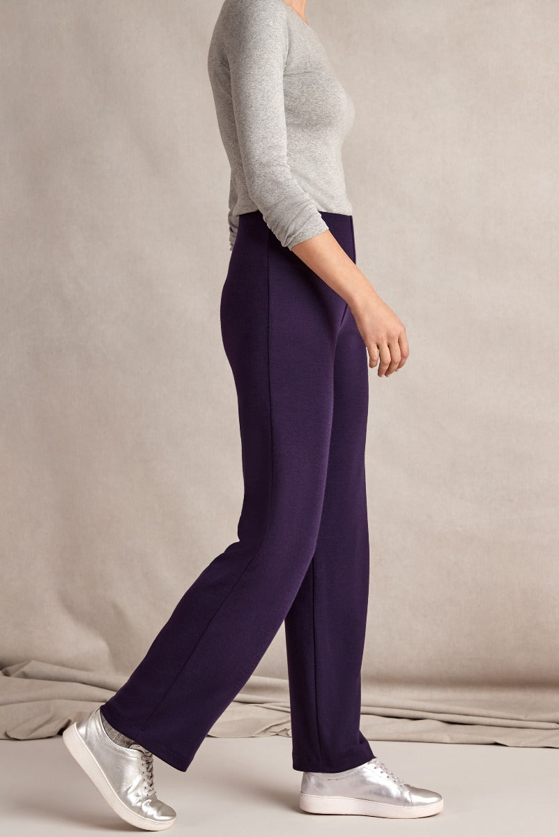 Lily Ella Collection elegant plum-colored wide-leg trousers paired with a casual grey top and metallic sneakers for a sophisticated yet relaxed look.