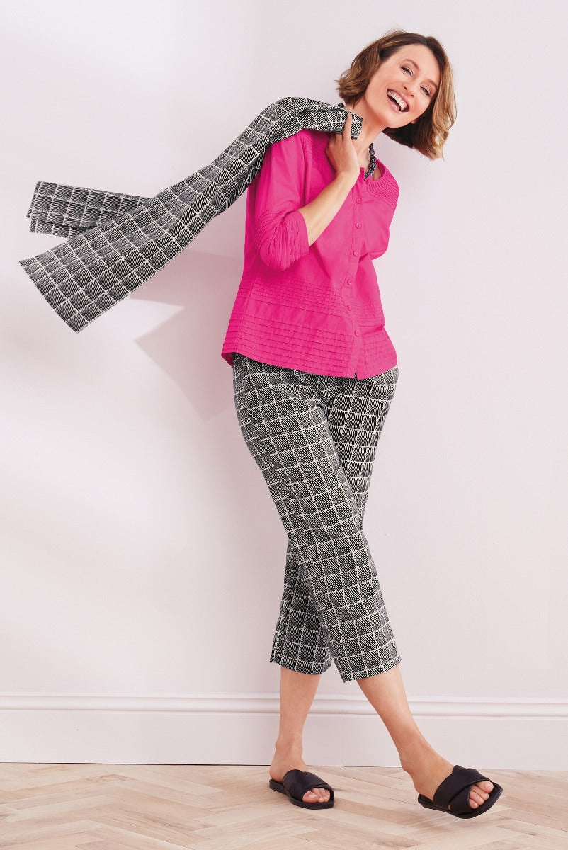 Lily Ella Collection vibrant pink button-up shirt paired with stylish geometric-patterned cropped trousers, casual black open-toe sandals for a chic summer look.