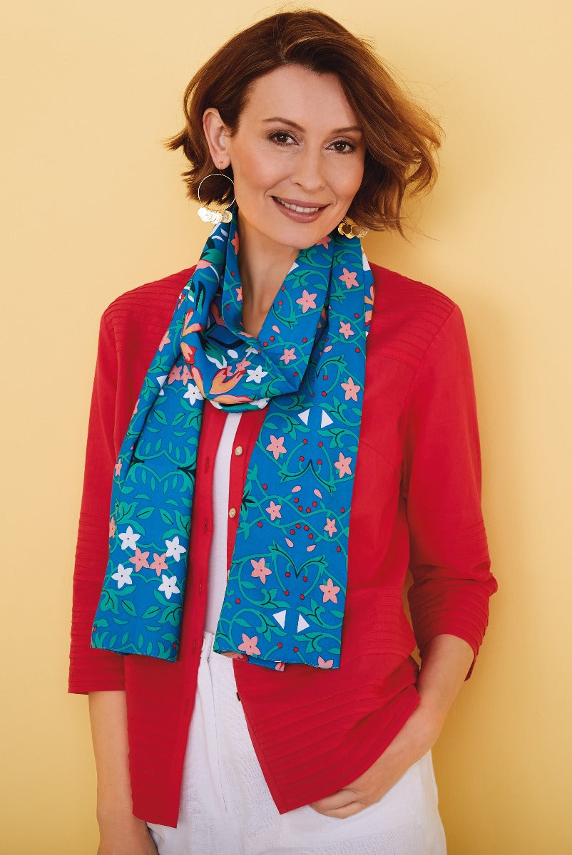 Lily Ella Collection vibrant blue floral scarf paired with a classic red cardigan and casual white top, featuring stylish spring fashion accessories.