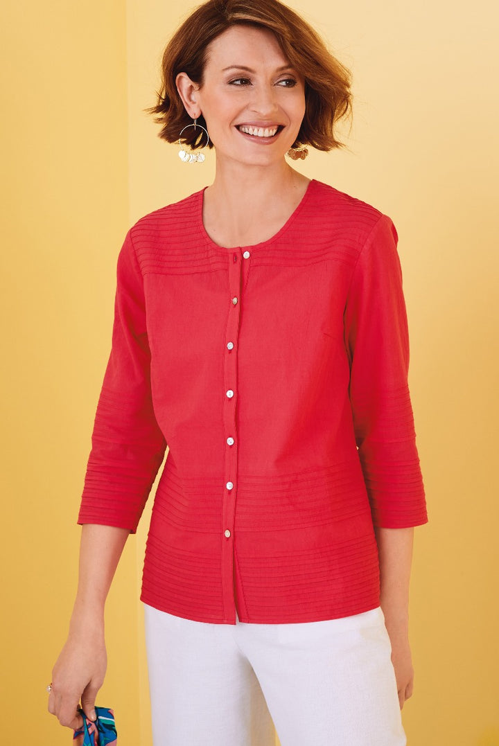 Lily Ella Collection red button-up textured cardigan, three-quarter sleeve, women's fashion, elegant casual wear, paired with white trousers and statement earrings against a vibrant yellow background.