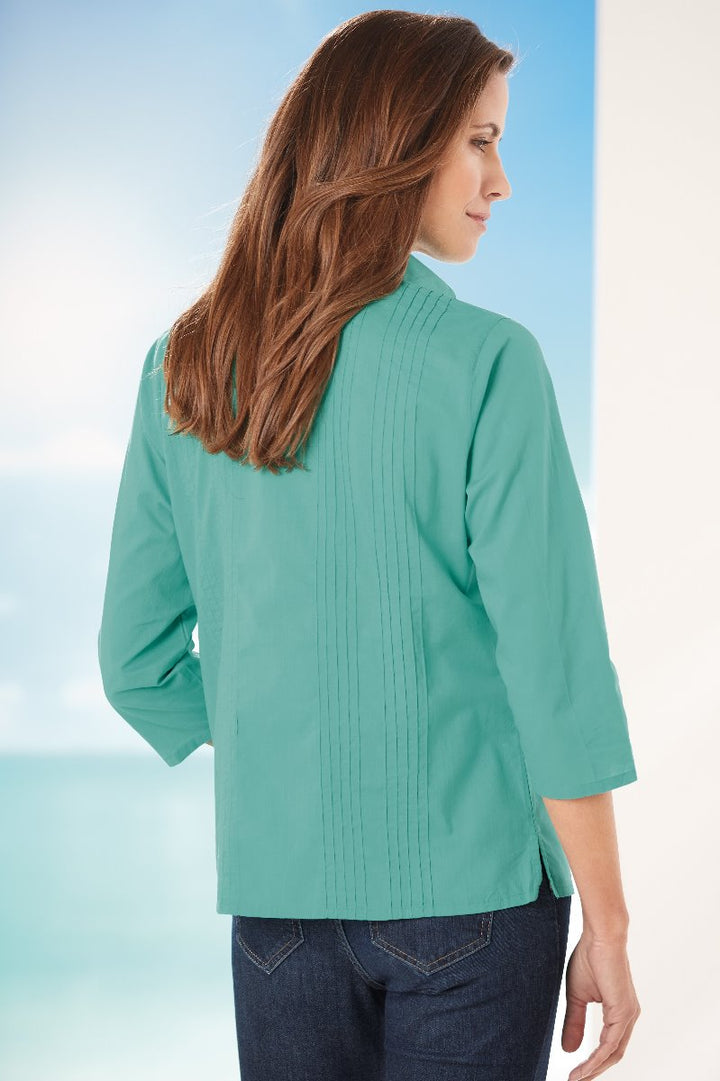 Lily Ella Collection turquoise pleated back detail blouse with three-quarter sleeves worn with denim for a casual look.