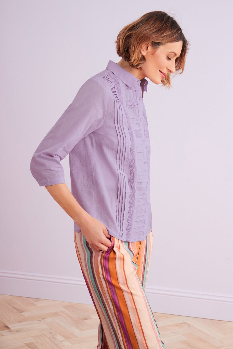 Lily Ella Collection elegant lilac button-up shirt with delicate lace detailing paired with vibrant striped trousers for a sophisticated casual look.