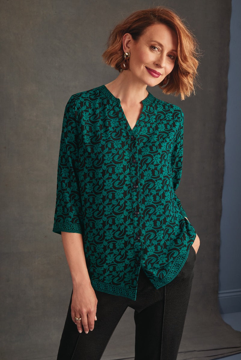 Lily Ella Collection elegant emerald green patterned blouse, stylish women's fashion, half-sleeve top with a sophisticated print, paired with black trousers.