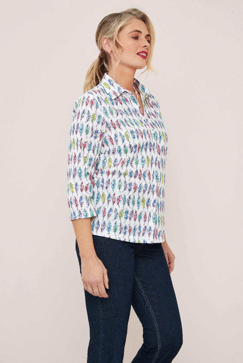 Lily Ella Collection white feather print blouse paired with dark denim jeans, showcasing casual chic style for women.