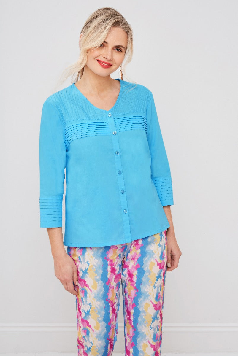 Lily Ella Collection sky blue cardigan with button-up front, ribbed texture details, and three-quarter sleeves, paired with colourful floral pattern trousers for a vibrant spring outfit.