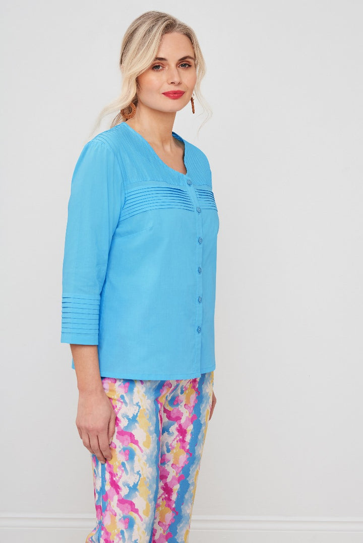 Lily Ella Collection women's sky blue button-up cardigan with pintuck detail paired with colorful floral print trousers, fashionable spring-summer outfit ideas.