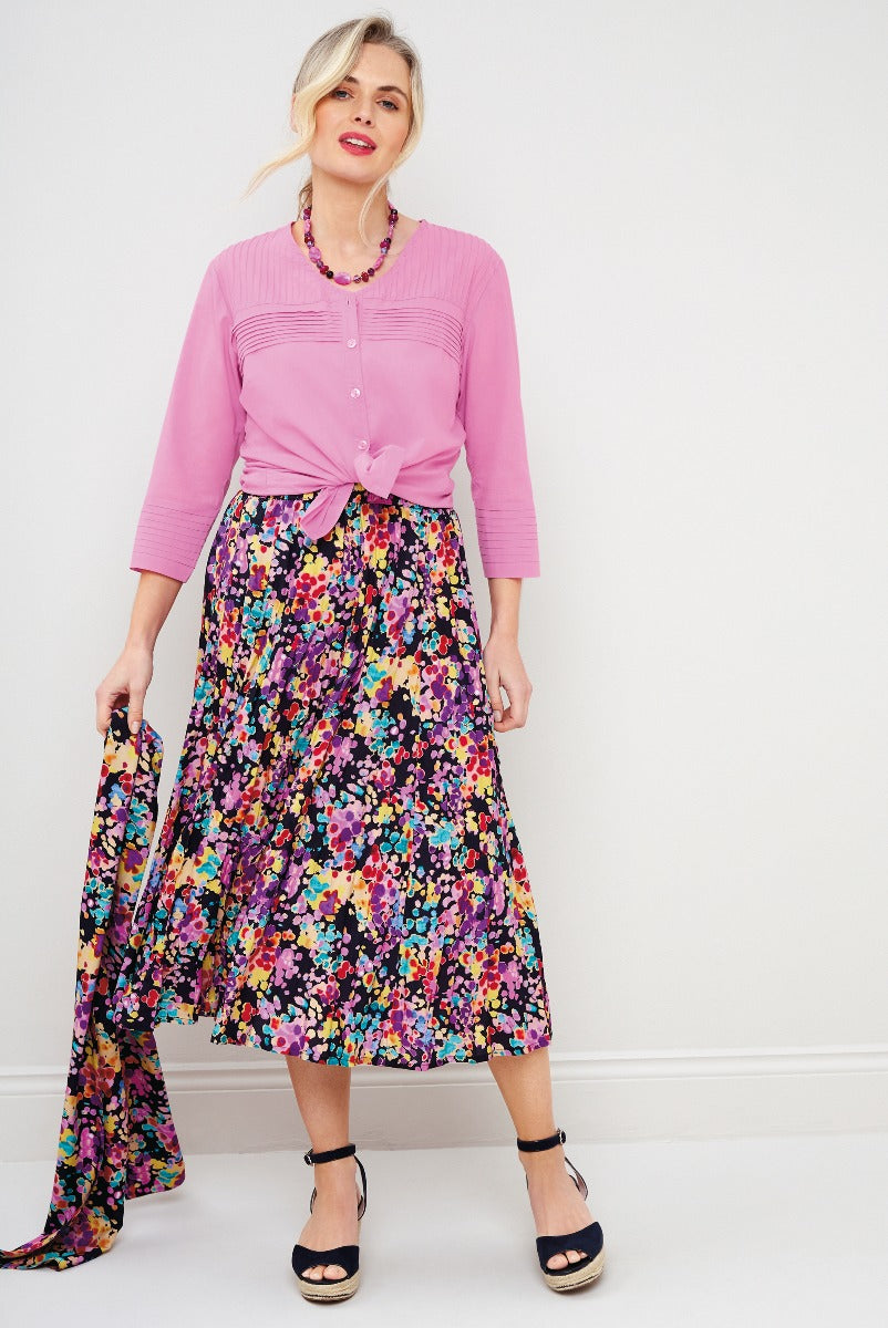 Lily Ella Collection pink 3/4 sleeve cardigan knotted at waist paired with vibrant floral print midi skirt and black ankle strap heels, stylish women's outfit idea