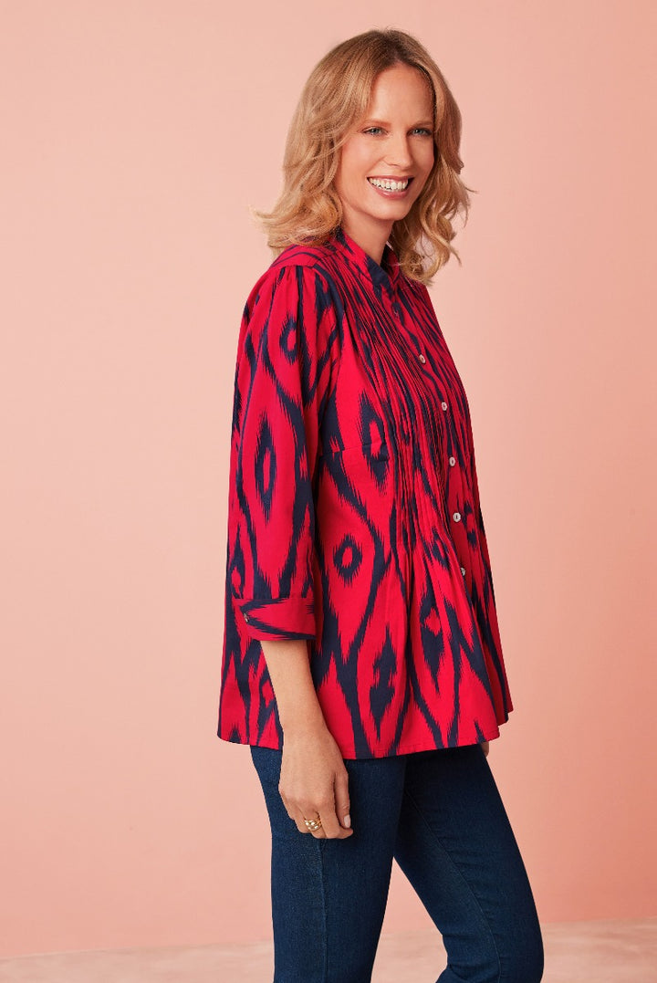 Lily Ella Collection vibrant red and navy ikat print blouse, comfortable 3/4 sleeve design, stylish women's casual wear, paired with classic dark blue jeans.