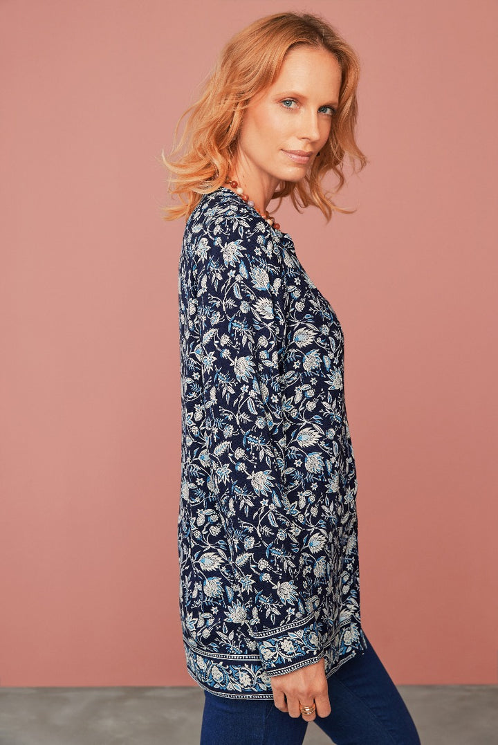 Lily Ella Collection navy blue floral patterned tunic top, elegant comfortable women's wear, stylish botanical print blouse with three-quarter sleeves and border design, model showcasing contemporary fashion against a soft pink background.