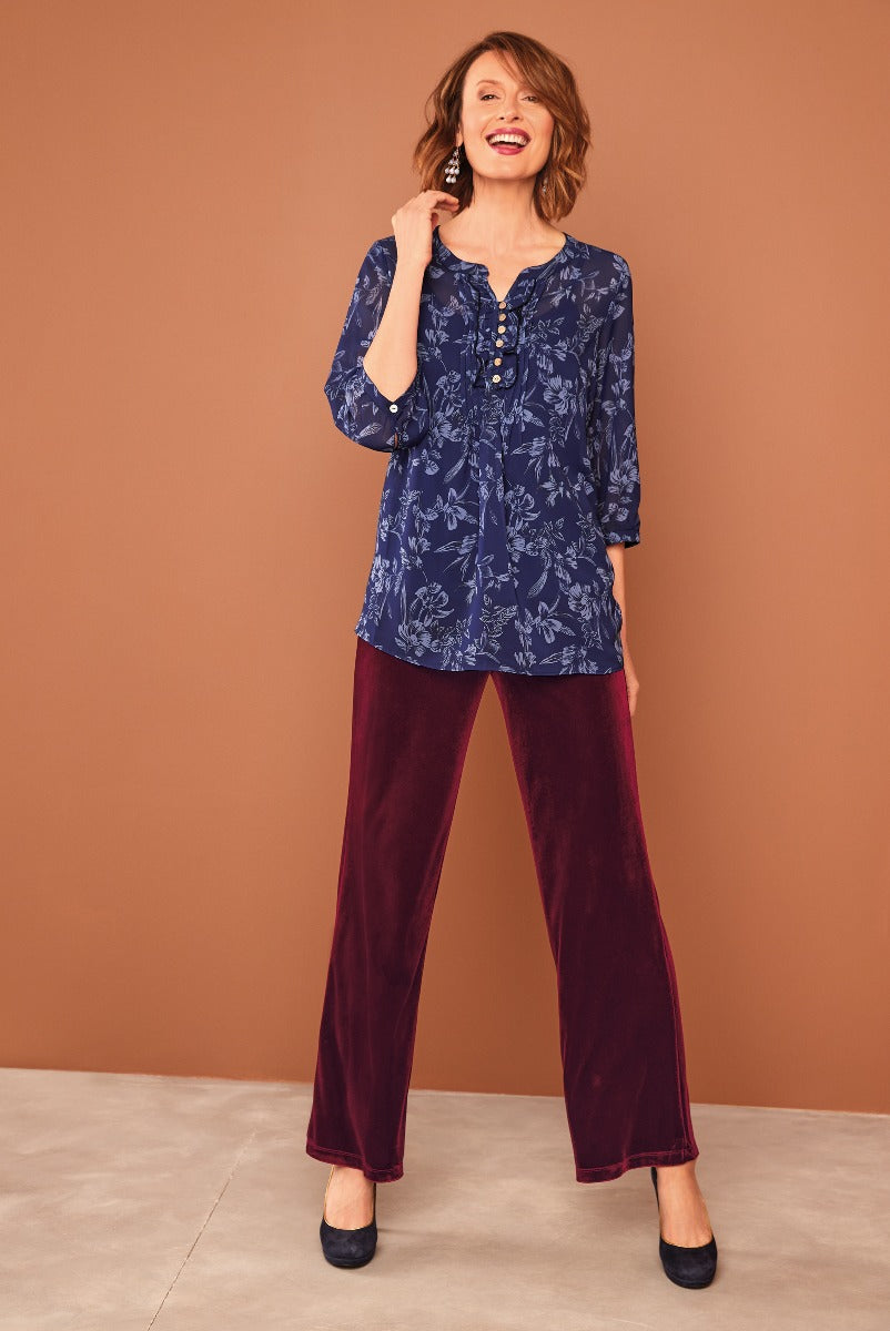 Lily Ella Collection women's fashion featuring a navy floral print tunic top with button details paired with luxurious burgundy velvet trousers and stylish black heels, presenting an elegant and contemporary casual look.