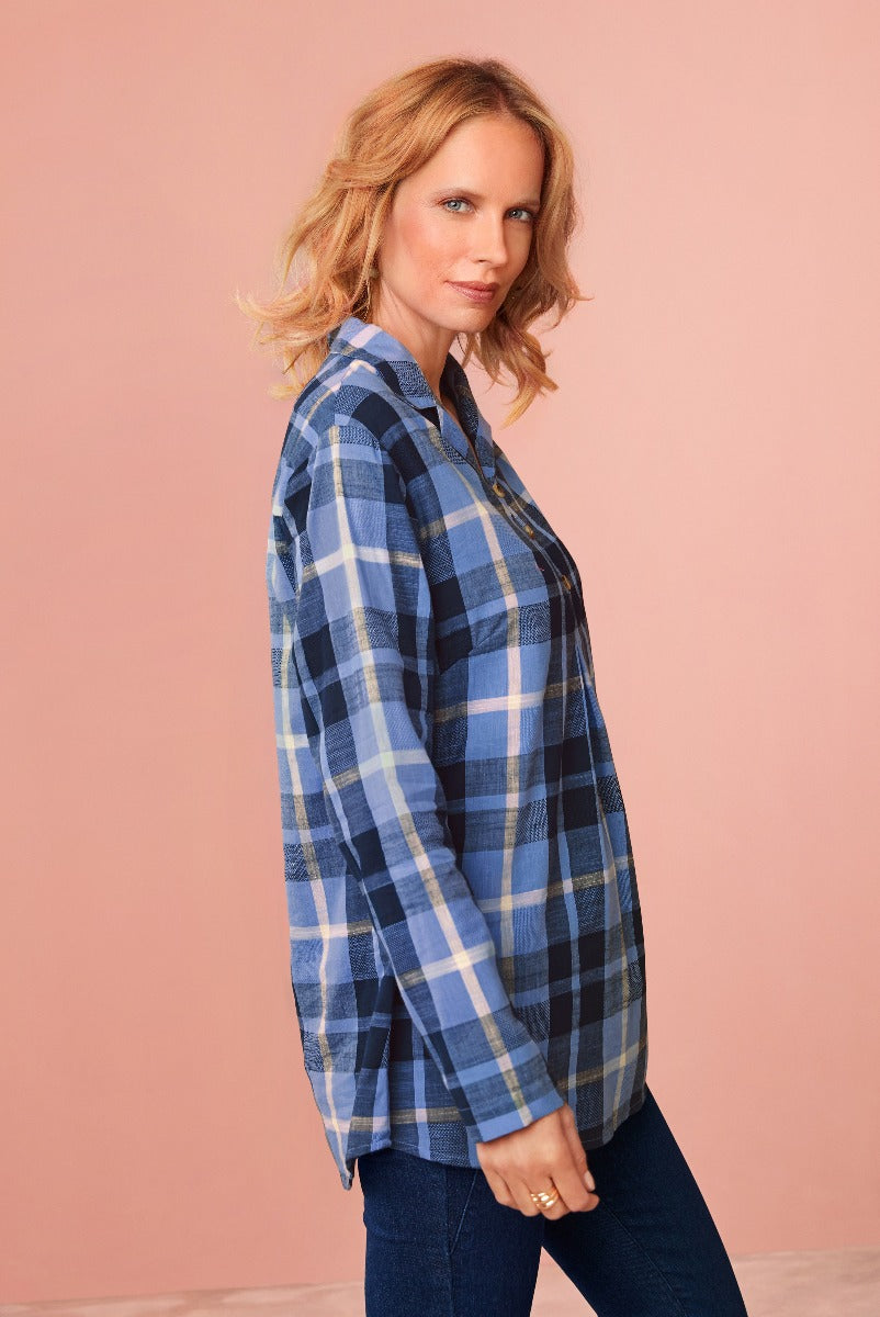 Lily Ella Collection blue checkered shirt stylish casual women's blouse with comfortable fit paired with dark denim jeans fashion model posing with pink background.
