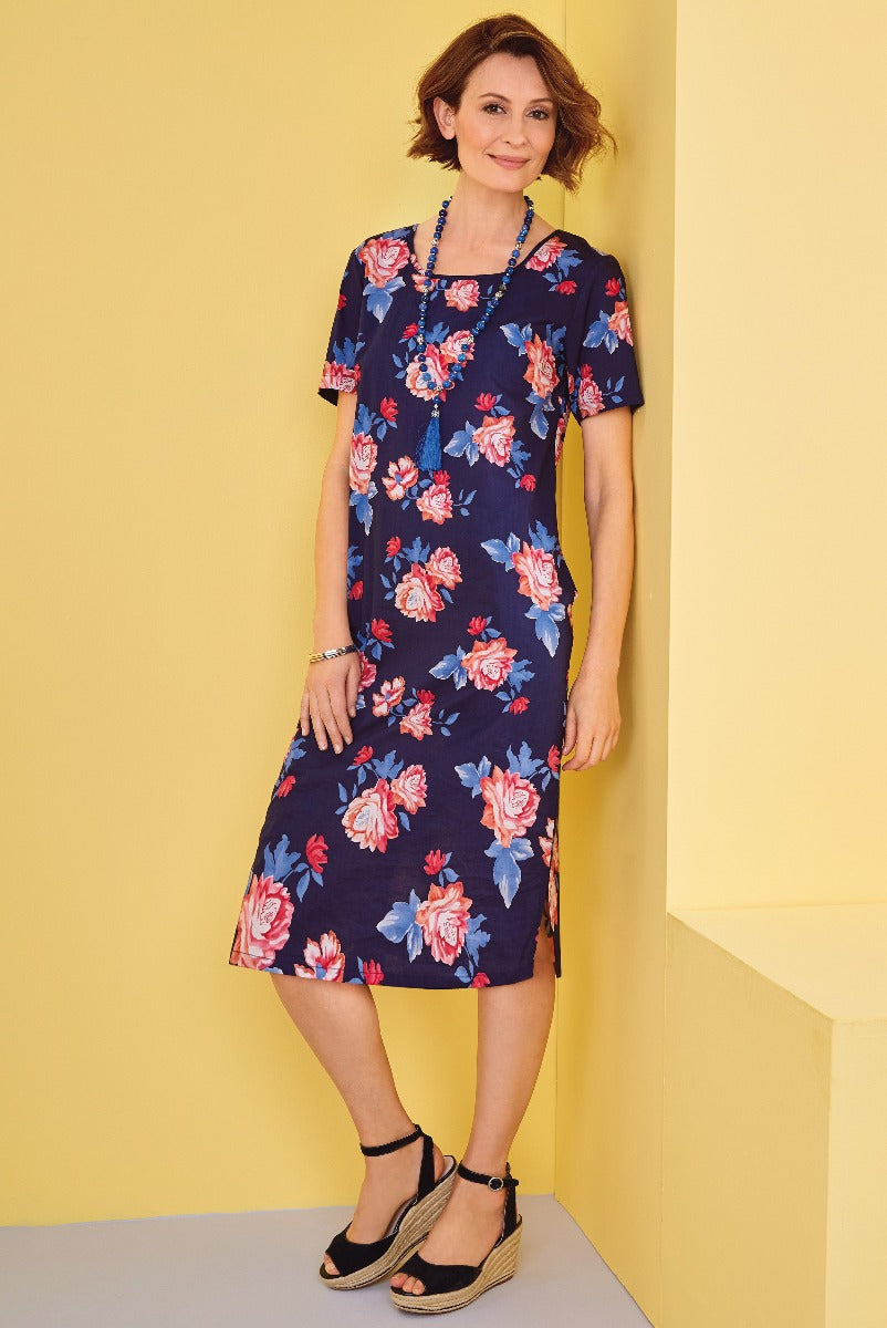 Lily Ella Collection navy floral dress, women's fashion, elegant daytime wear, blue and pink flower print, knee-length summer dress, paired with black wedge sandals, stylish outfit idea.