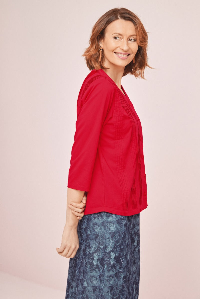 Lily Ella Collection model wearing red textured cardigan and stylish patterned blue skirt, fashion-forward women's apparel, elegant mature woman showcasing contemporary clothing
