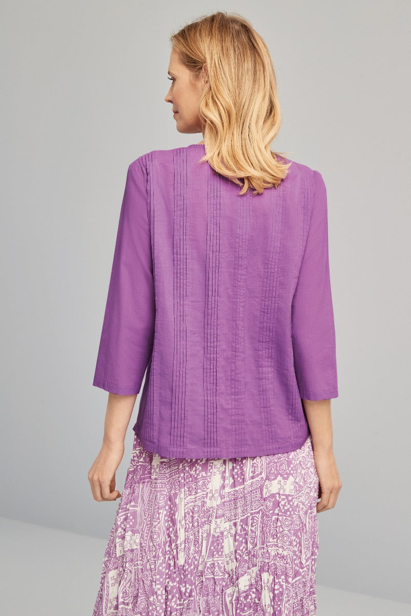 Lily Ella Collection purple tunic top for women, three-quarter sleeve design, elegant casual wear, paired with patterned skirt, rear view, stylish clothing for mature women