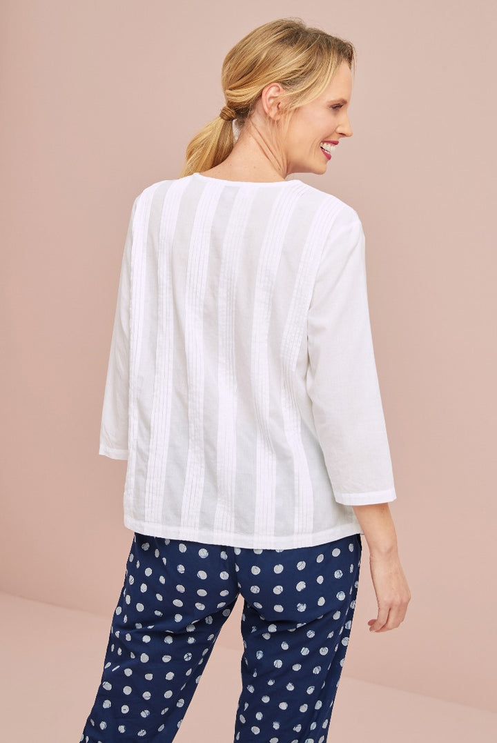 Lily Ella Collection white striped blouse paired with navy polka dot trousers, elegant casual women's outfit, back view