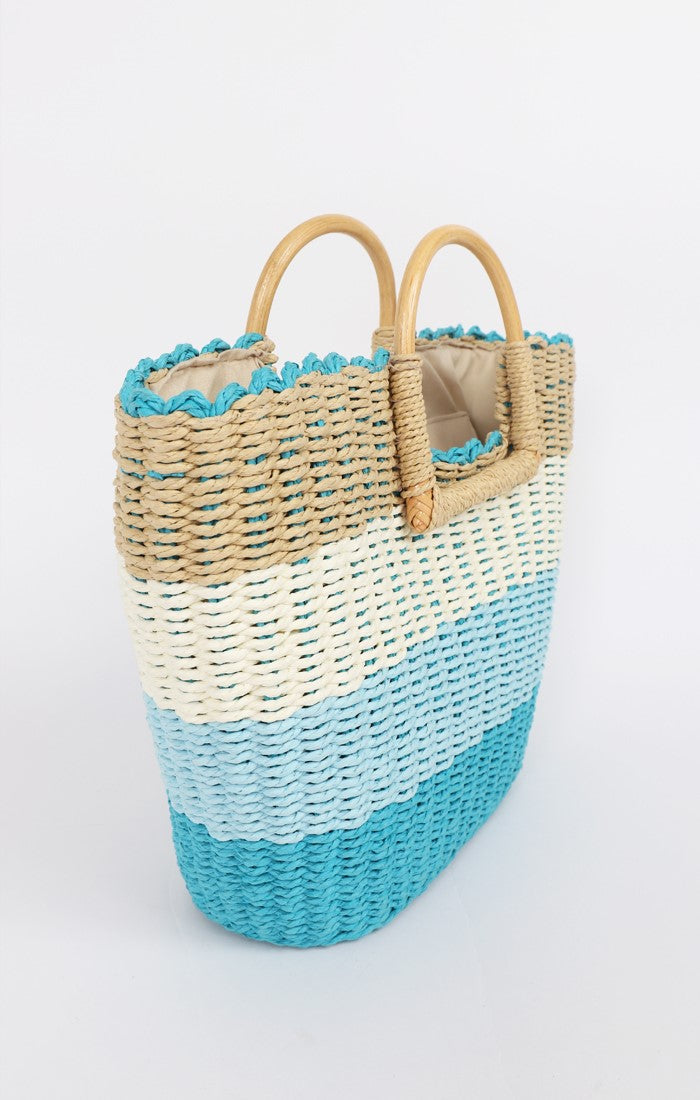 Lily Ella Collection two-tone blue and natural handwoven straw beach bag with bamboo handles and textured detail, perfect for summer accessory fashion.