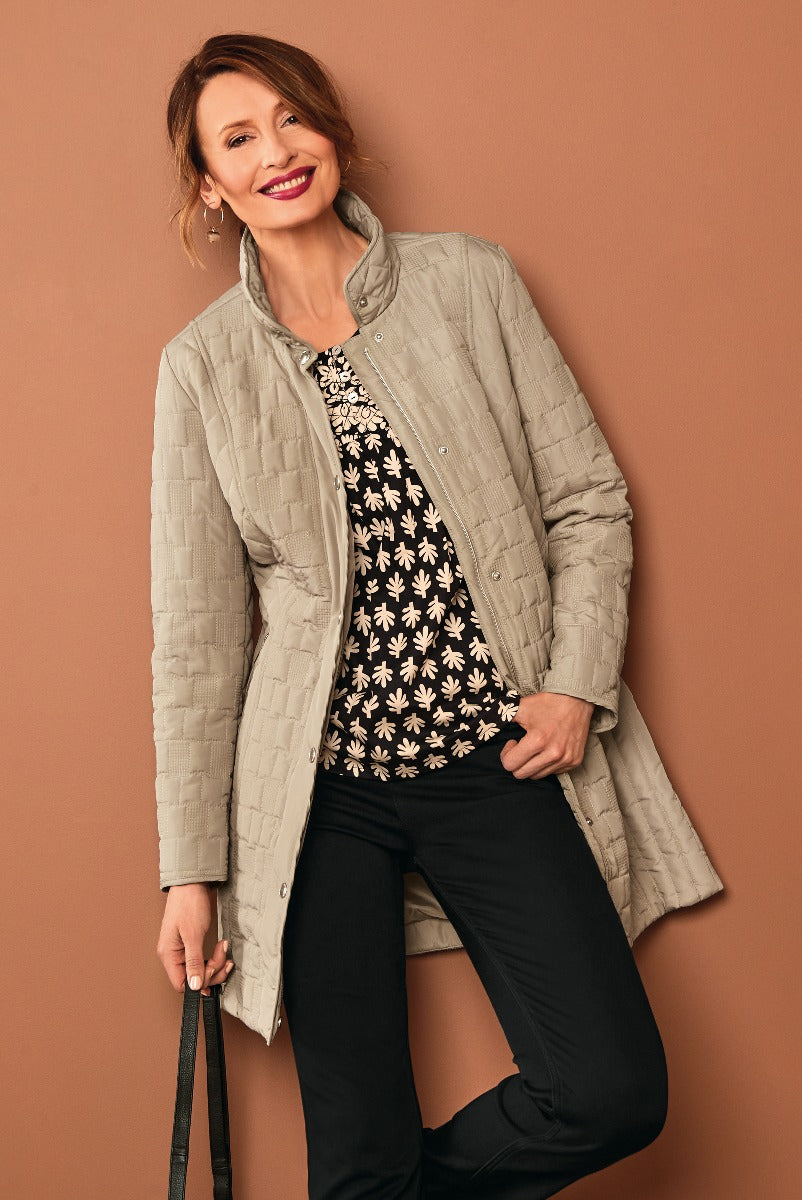 Lily Ella Collection stylish beige quilted jacket paired with a black and white floral top and chic black trousers, perfect for a sophisticated casual look.