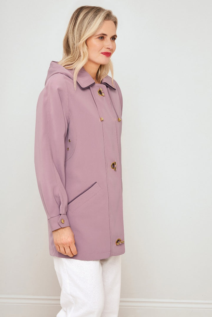 Lily Ella Collection stylish mauve jacket with gold-tone buttons, front pockets, and hood, model wearing white trousers, showcasing casual spring outerwear for women.