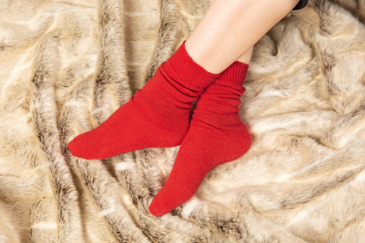 Lily Ella Collection cozy red socks on faux fur background, comfortable women's loungewear socks, warm knitted winter accessories, stylish red hosiery.