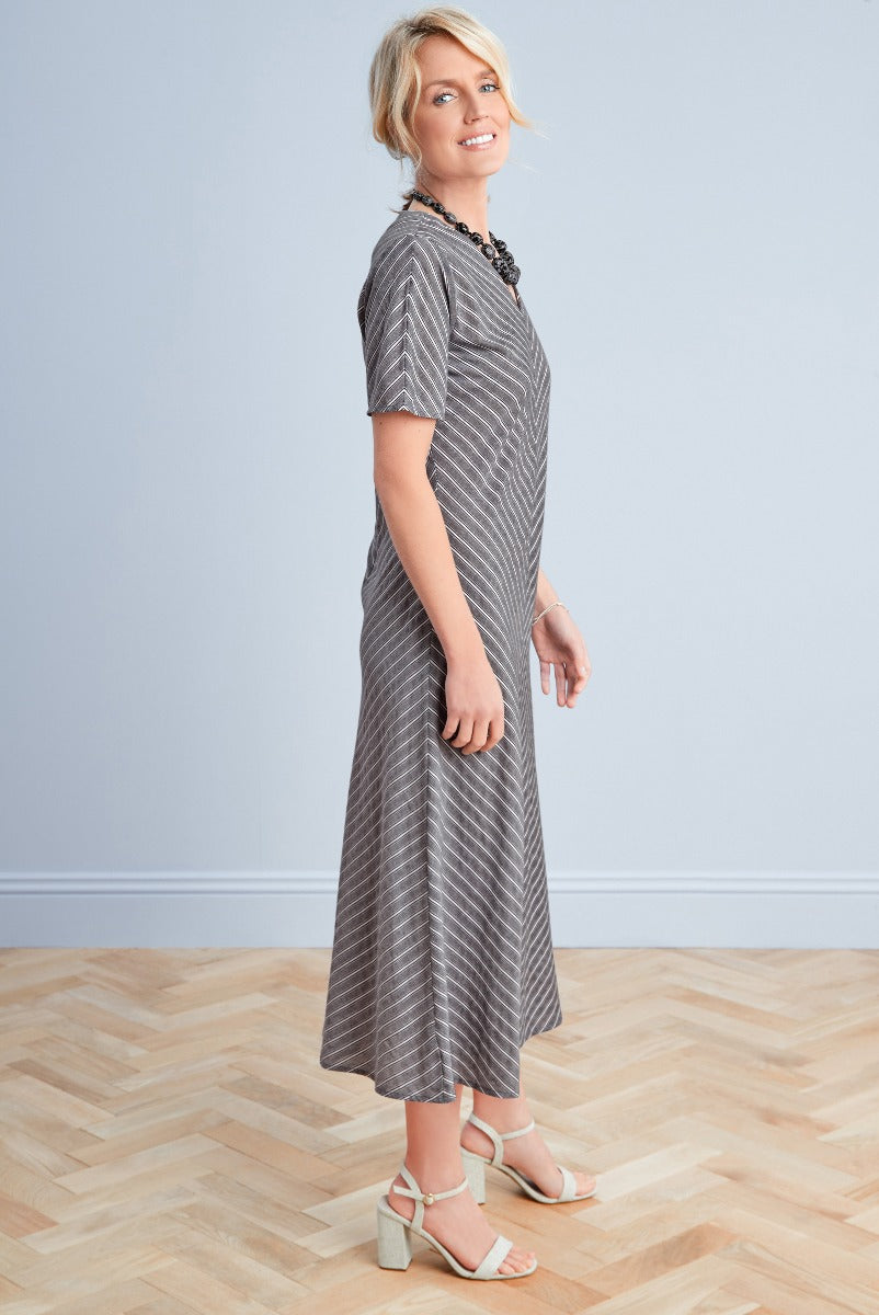 Lily Ella Collection elegant grey herringbone midi dress with short sleeves, paired with cream strappy heels and statement necklace, perfect for casual chic style.