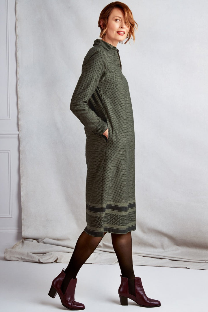 Lily Ella Collection olive green patterned turtleneck knit dress with hem detailing paired with maroon ankle boots for stylish autumn-winter fashion.