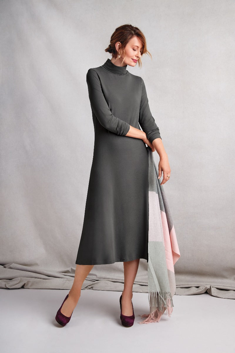 Lily Ella Collection elegant charcoal midi dress with high neck, model holding pastel color block scarf, paired with plum heels, stylish women's autumn fashion.