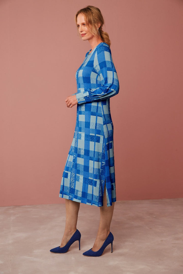 Lily Ella Collection blue checked midi dress with long sleeves and coordinating blue high heels on a model against a pink backdrop