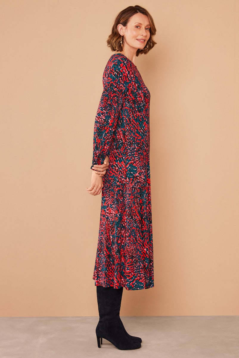 Lily Ella Collection red and blue patterned midi dress with long sleeves matched with black suede boots on model against a neutral background