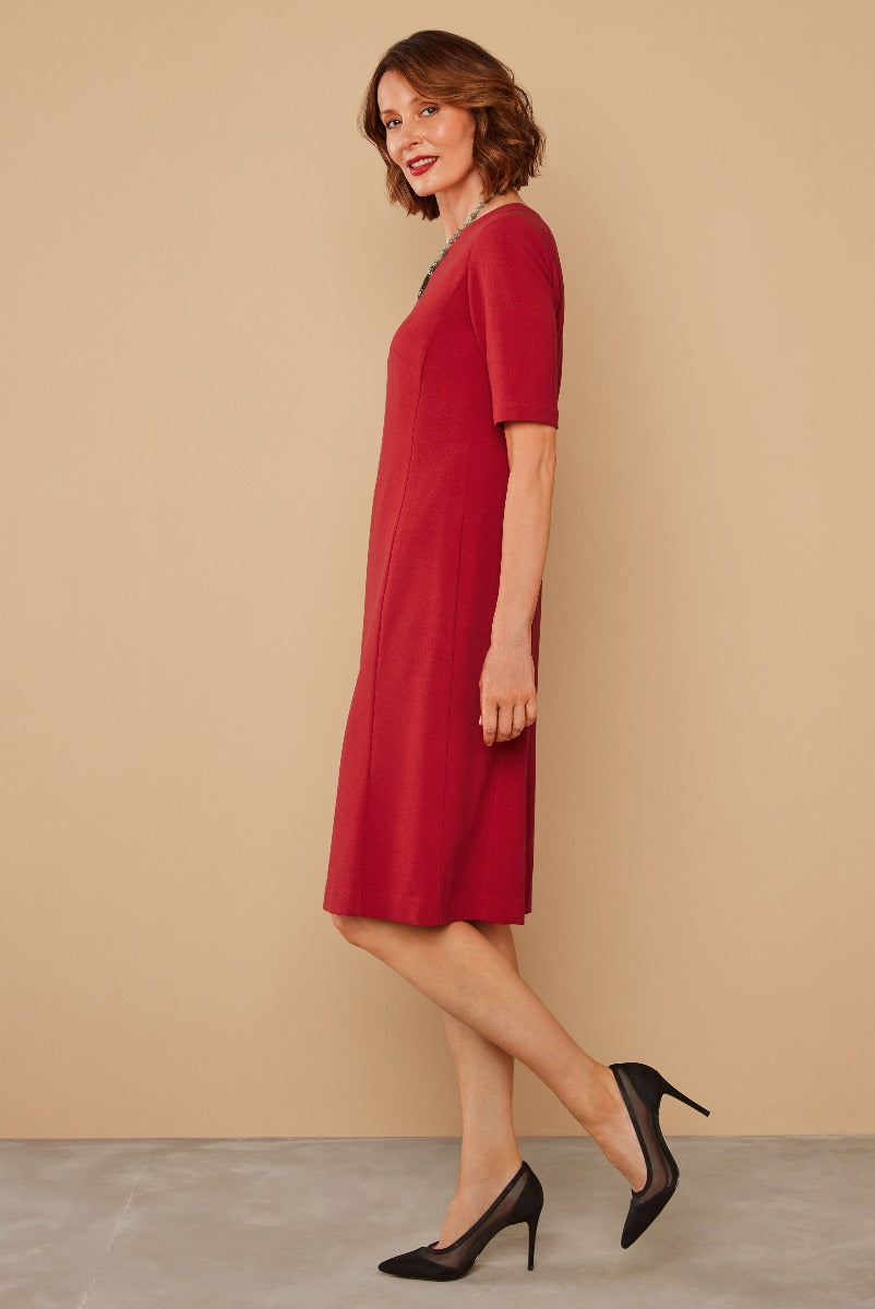 Lily Ella Collection stylish model wearing a classic red knee-length dress paired with elegant black heels, perfect for casual and semi-formal occasions.