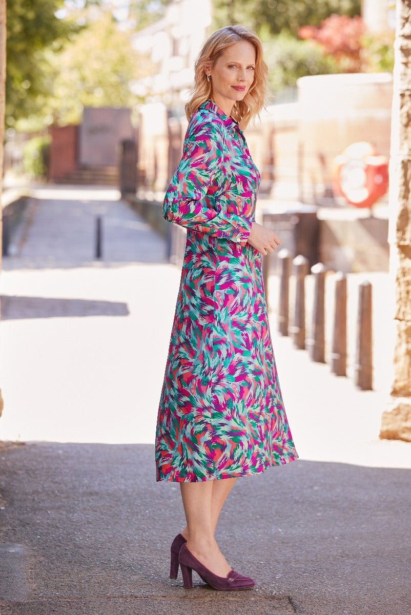 Lily Ella Collection vibrant pink and teal tropical print midi dress with long sleeves, stylish daytime look, paired with plum high heels.