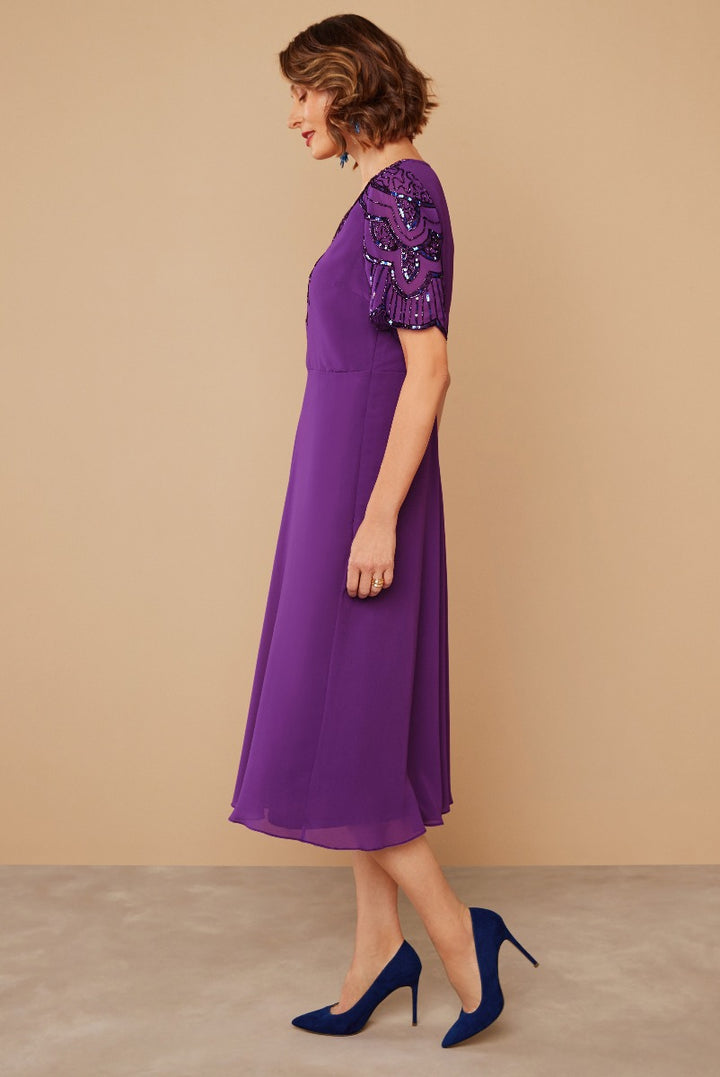 Lily Ella Collection elegant purple midi dress with intricate beaded sleeve detail and navy blue high heels