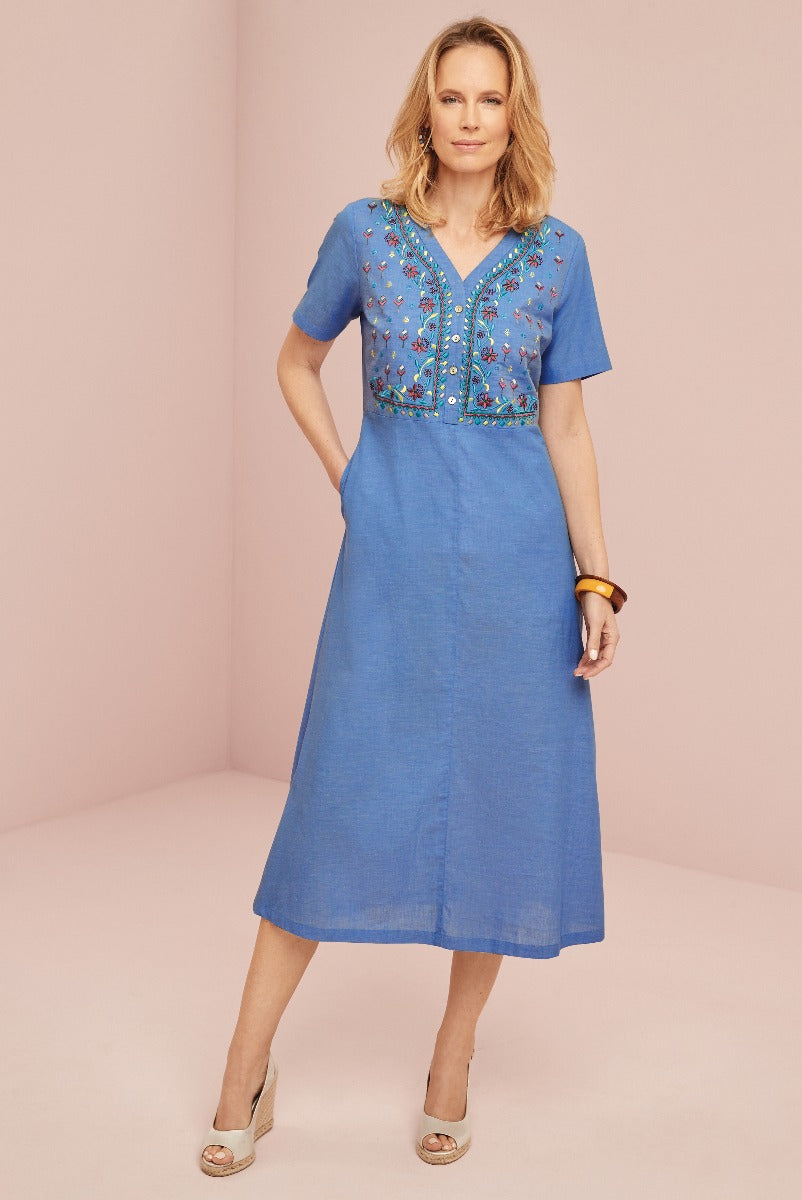 Lily Ella Collection cornflower blue midi dress with colorful embroidery detail, short sleeves, and v-neckline, styled with coordinating accessories.