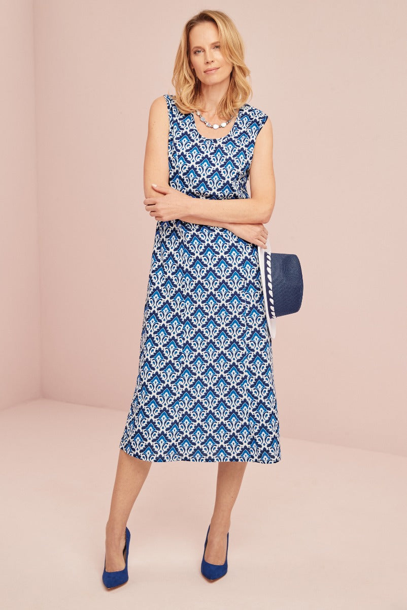 Lily Ella Collection blue and white patterned sleeveless dress, stylish women's summer fashion, elegant mid-length outfit with matching blue heels and accessories.