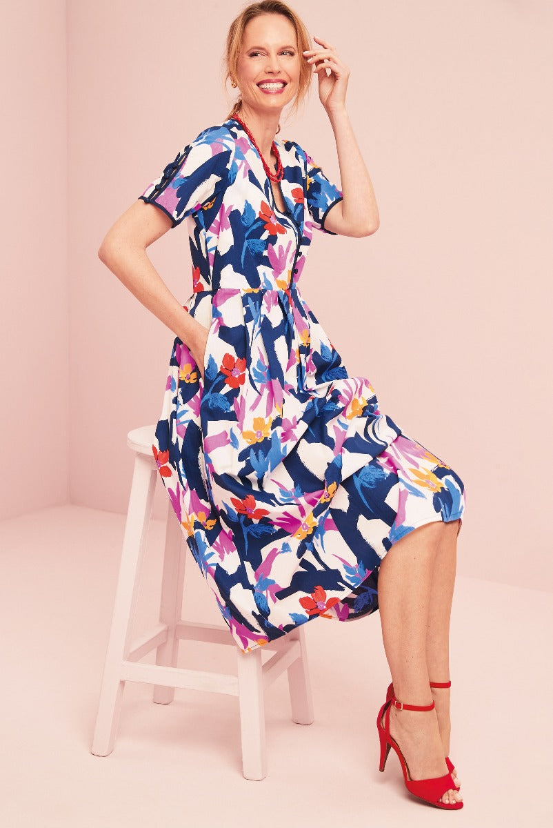Lily Ella Collection vibrant multicolor floral print dress for women sitting on white stool with stylish red high heels