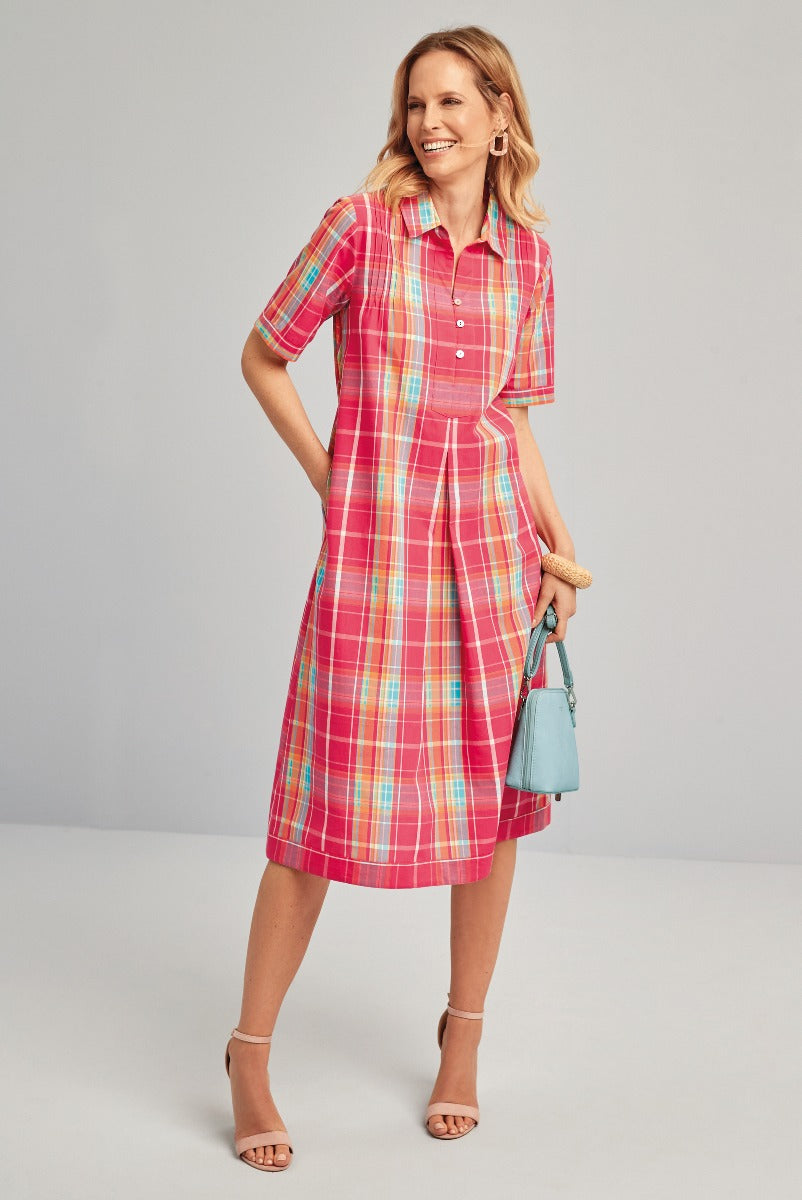 Lily Ella Collection vibrant pink and turquoise plaid shirt dress, stylish knee-length, summer fashion, paired with tan ankle strap heels and light blue handbag.