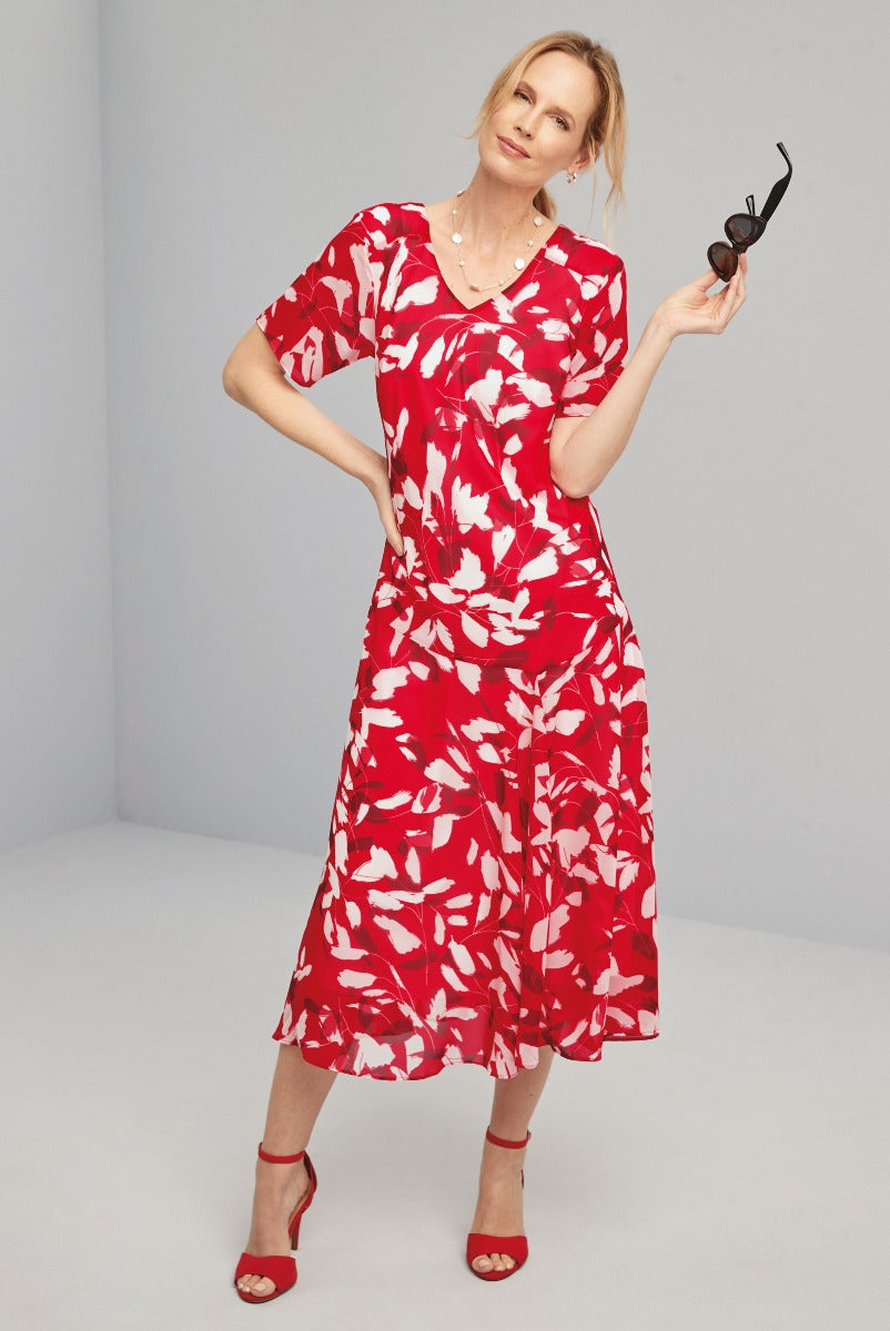 Lily Ella Collection mid-length red and white floral dress, elegant v-neck style, matched with red strappy heels and sunglasses, summer fashion for women.