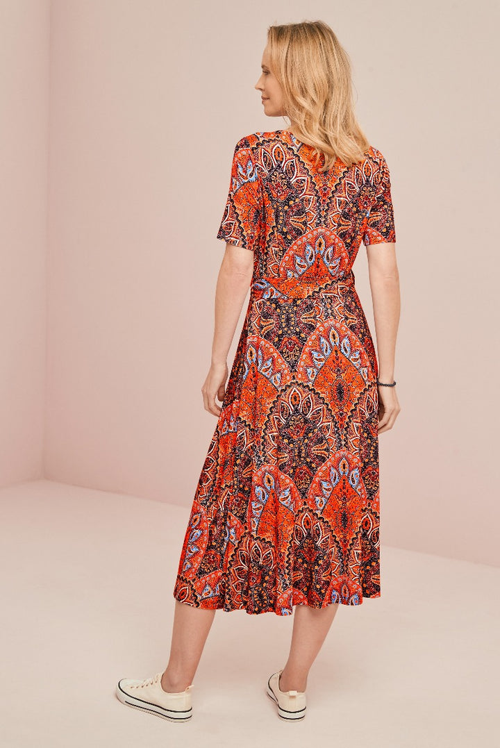 Lily Ella Collection orange paisley pattern midi dress with short sleeves and flared skirt on model with neutral background