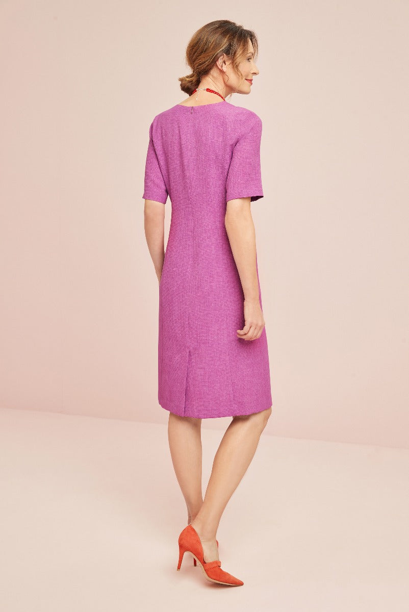Lily Ella Collection elegant magenta shift dress with short sleeves, styled with vibrant red heels, showcasing back view on a pastel pink background.
