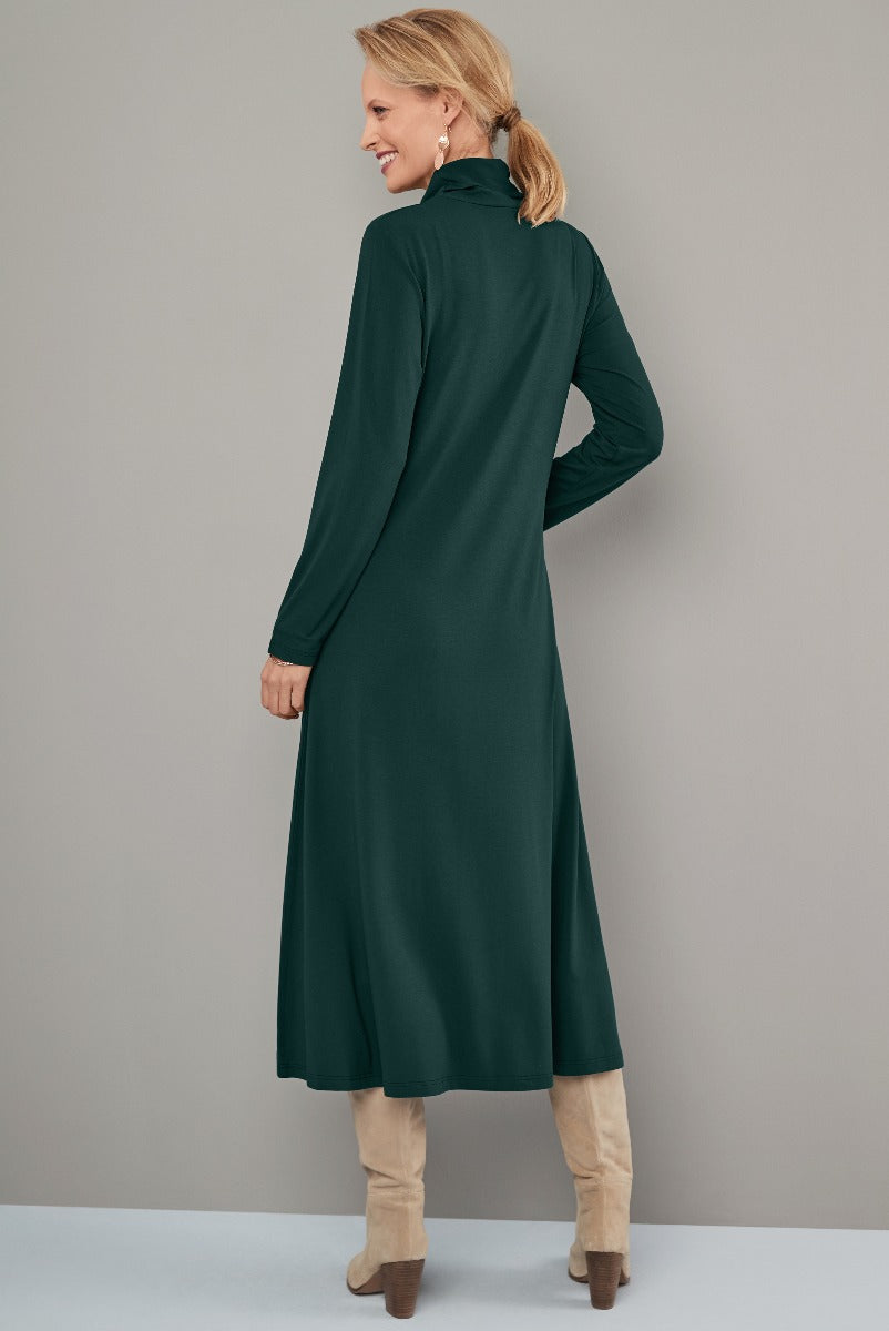 Lily Ella Collection elegant green midi dress with high neck and long sleeves, styled with beige knee-high boots for a sophisticated autumn fashion look.