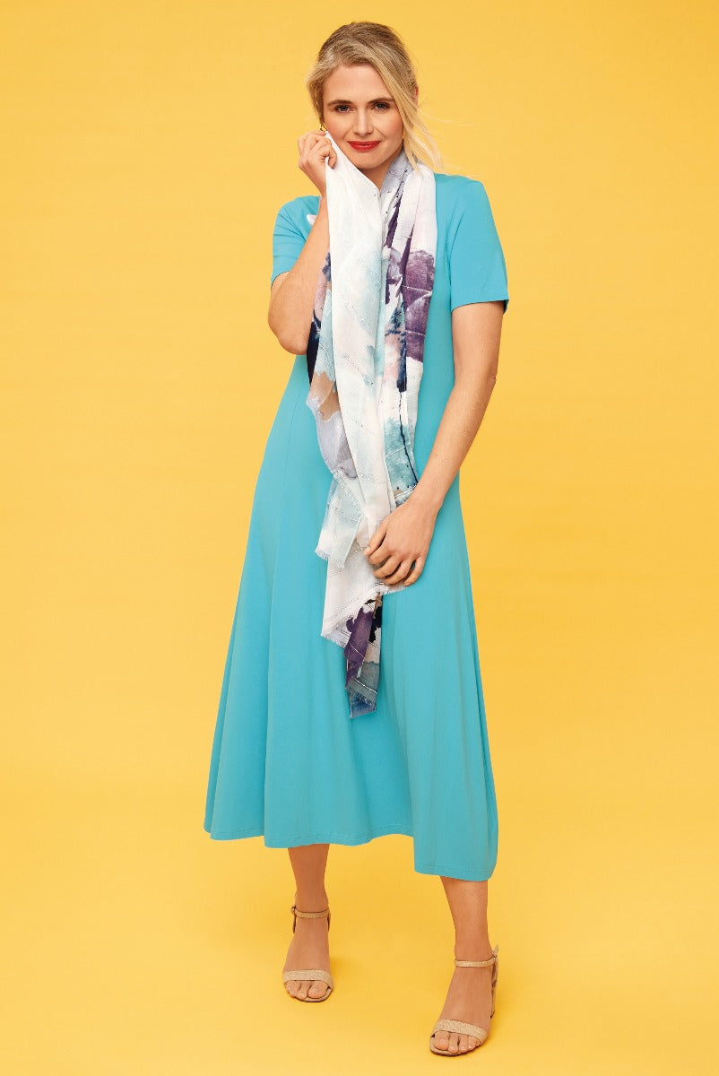 Lily Ella Collection aqua blue midi dress with elegant short sleeves and fashionable pastel printed scarf on a female model against a yellow background, showcasing casual chic summer style.