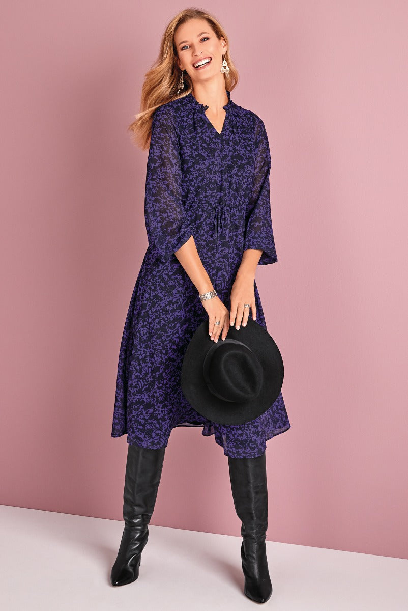 Lily Ella Collection elegant navy floral mid-length dress with cinched waist, paired with black knee-high boots and accessories for a chic autumn look