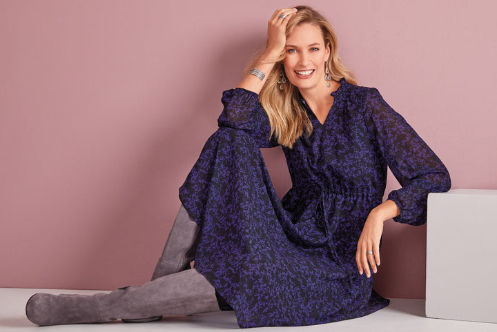 Lily Ella Collection navy blue floral-patterned maxi dress with long sleeves, cinched waist, and v-neckline paired with gray suede boots, model posing in stylish autumn outfit.