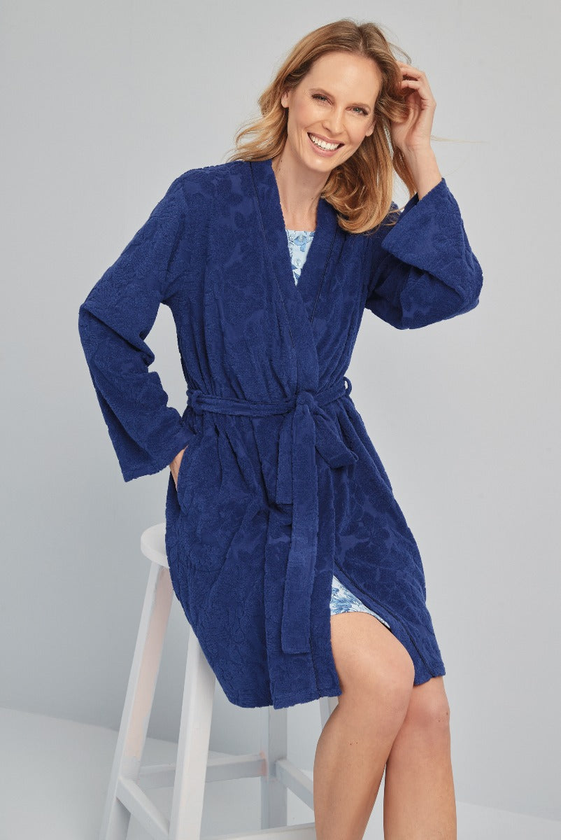Lily Ella Collection women's navy textured robe with tie waist, elegant loungewear, comfortable chic style, model posing on white stool showing dress underneath