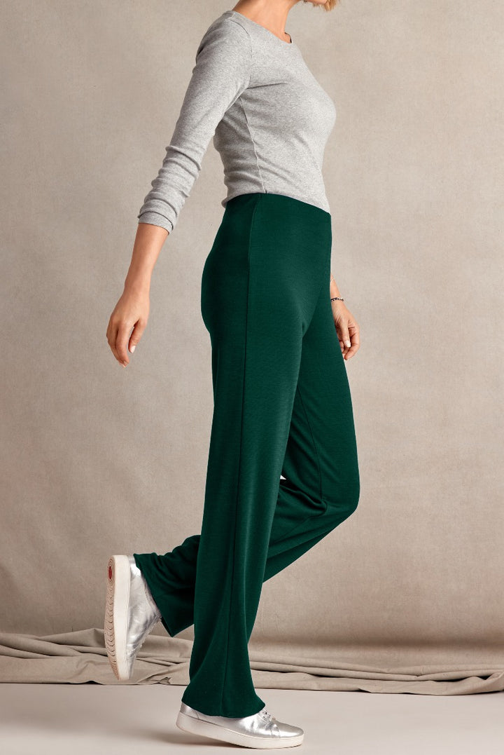 Lily Ella Collection elegant dark green palazzo pants for women, casual comfortable wide-leg trousers paired with grey top and silver sneakers.